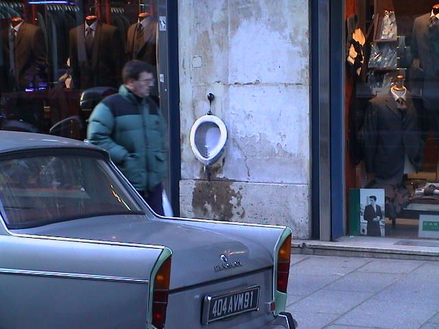 paris, ein schönes silbriges altes auto ein passant und ein pissoir, barbarella ist und war hier
